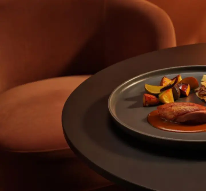 Gourmet fogás meleg narancs fényekben tálalva a Pannon Zóna éttermében.